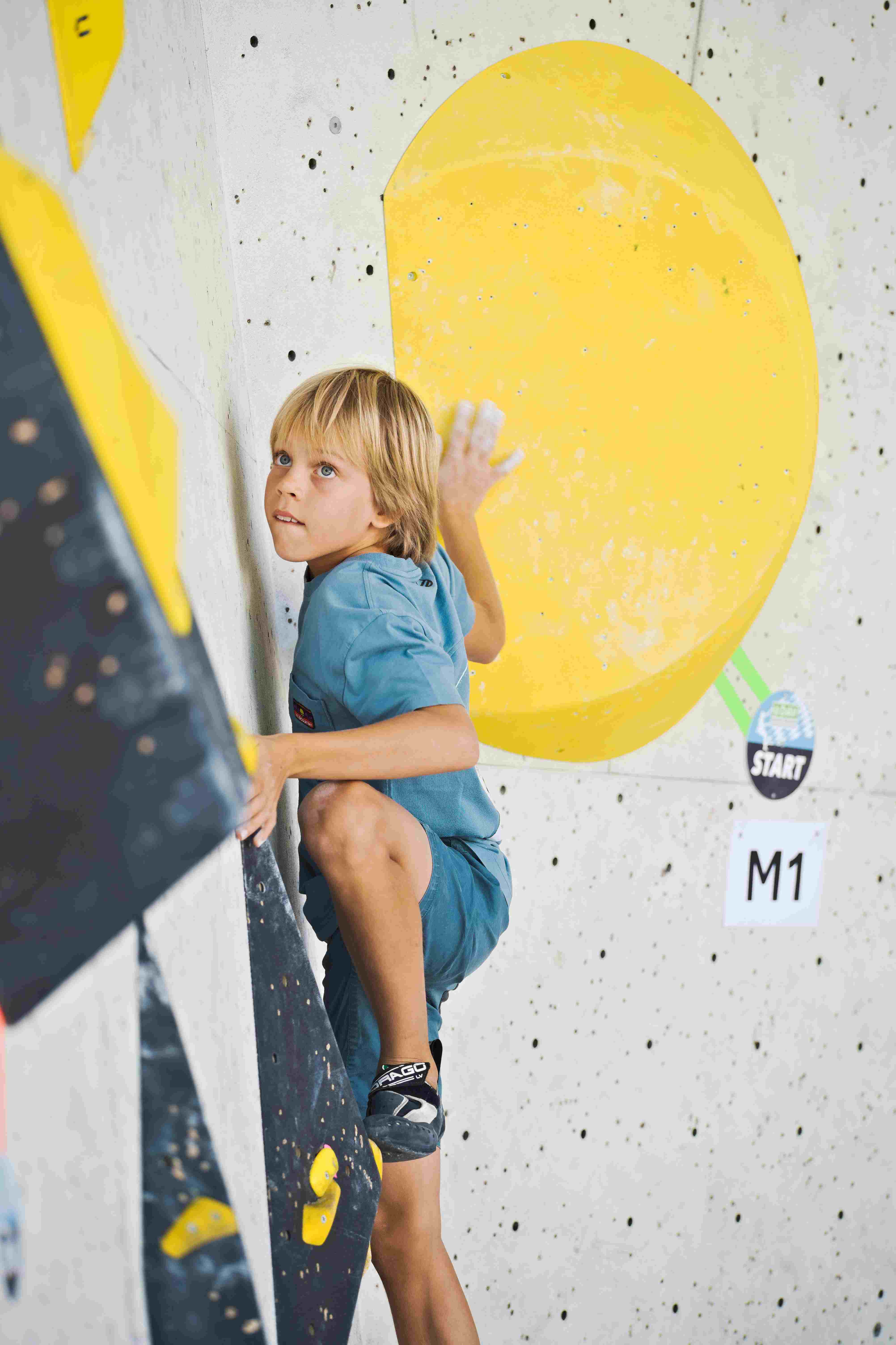 junger Boulderer in einem Wettkampfboulder